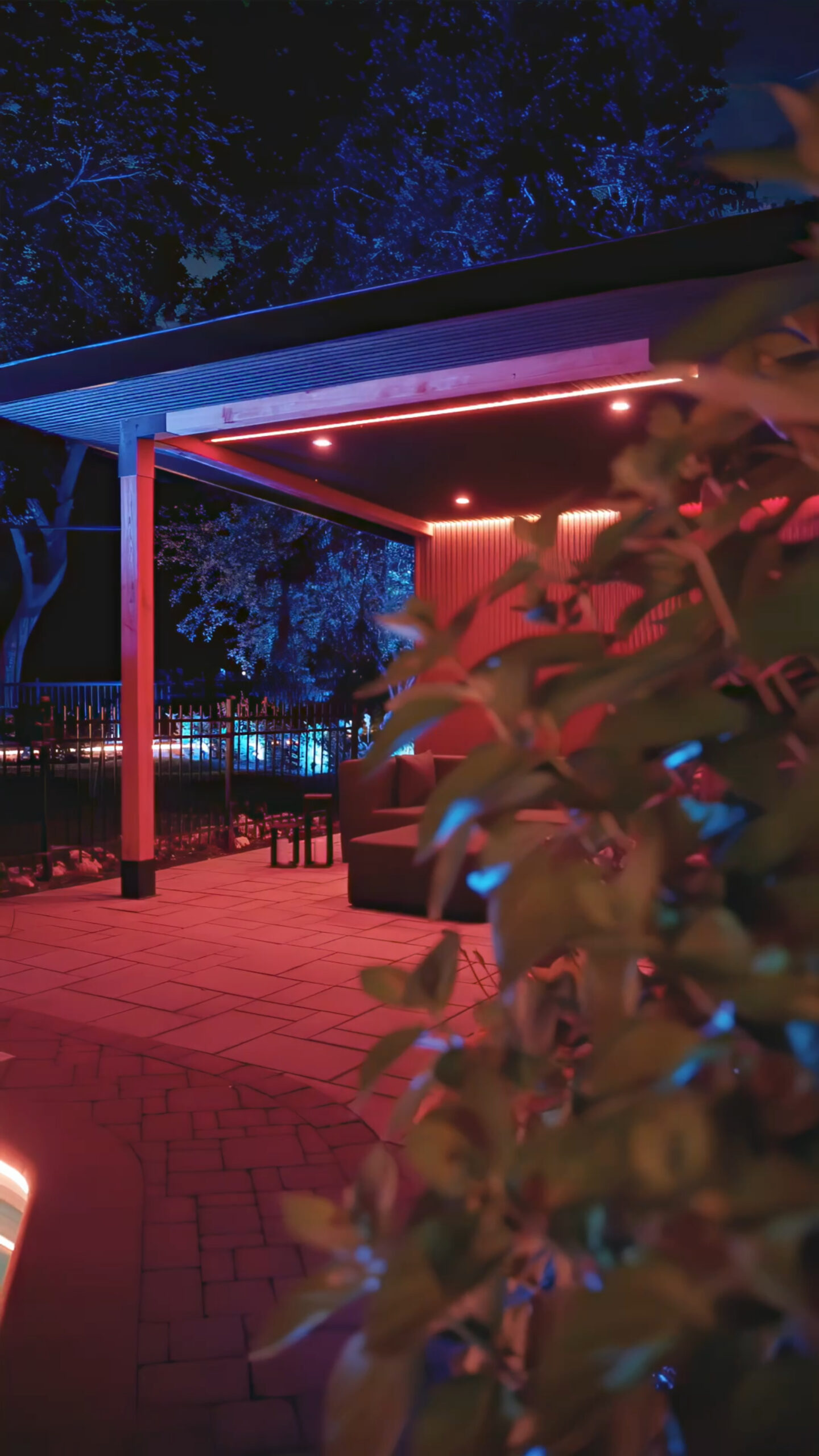 Low walls and steps around a pool accented with pink and purple LED strips