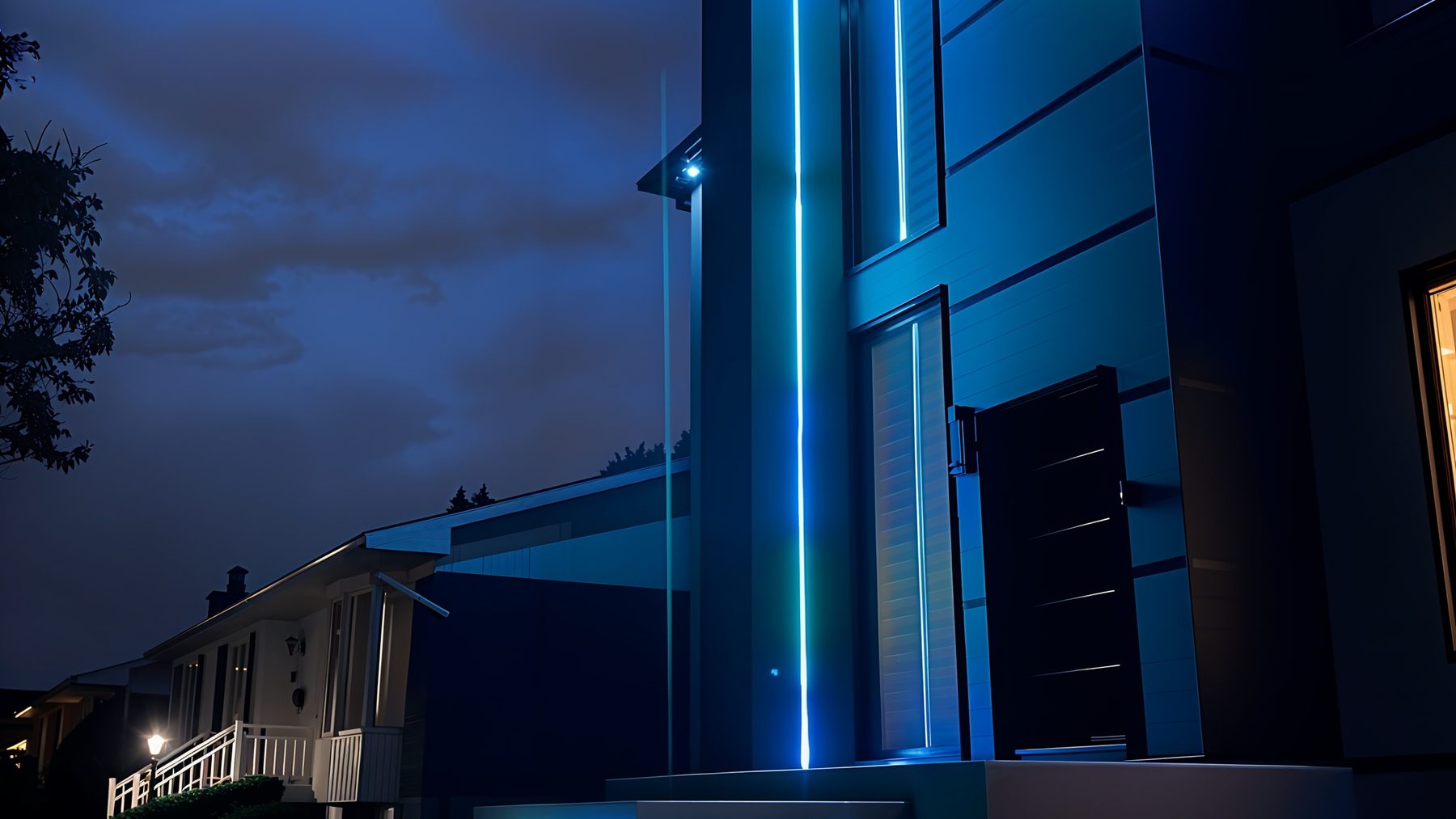Colonne d'entrée d'une maison contemporaine soulignée d'un trait de néon bleu, marches flottantes éclairées par-dessous