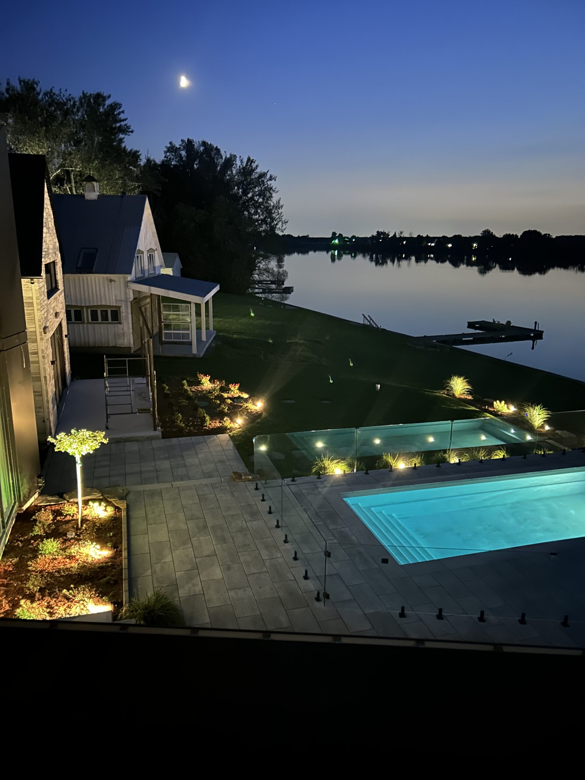 Flower beds and the front steps illuminated by low-mounted spotlights