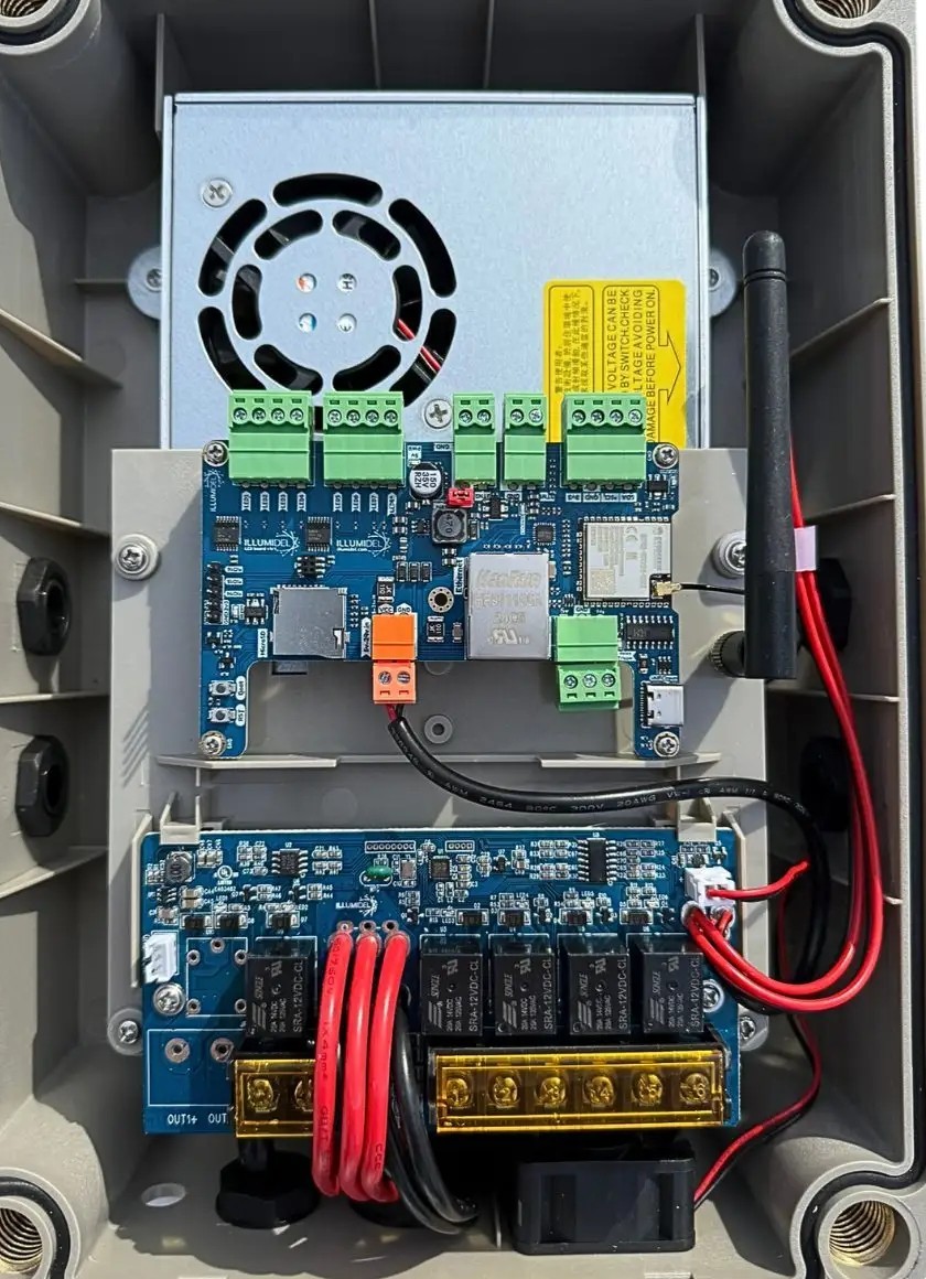 Inside the IllumiDEL The Box controller: power supply at the top, control board with 8 data terminals, output board with 4 combined outputs at the bottom